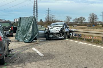 Zerstörtes Auto, links ein Leichenwagen