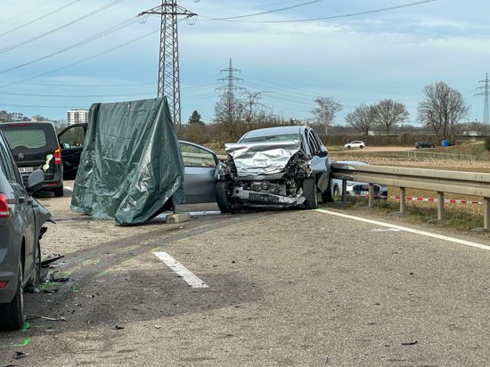 Zerstörtes Auto, links ein Leichenwagen
