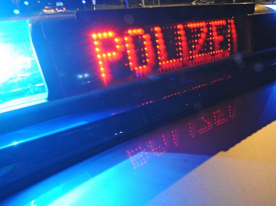 Die Aufschrift „Polizei“ leuchtet auf einem Polizeifahrzeug.