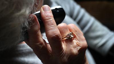 Eine ältere Frau telefoniert mit einem schnurlosen Festnetztelefon. Unbekannte haben von einer 87-Jährigen in Ettlingen (Landkreis Karlsruhe) mittels Enkeltrick 10 000 Euro ergaunert. +++ dpa-Bildfunk +++