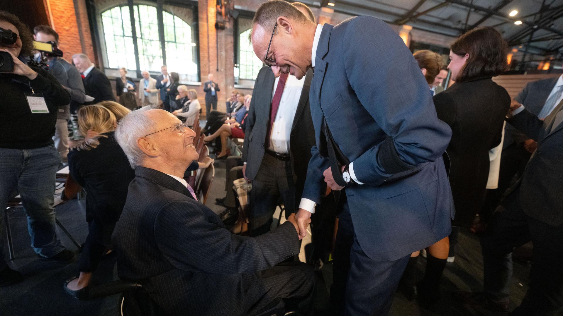 Wolfgang Schäuble (CDU), ehemaliger Bundestagspräsident, und Friedrich Merz, Bundesvorsitzender der CDU, begrüßen sich vor Beginn eines Festakts anlässlich des 80. Geburtstags Schäubles.
