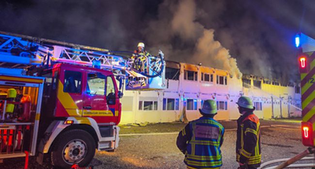 Feuerwehrleute löschen brennende Wohncontainer
