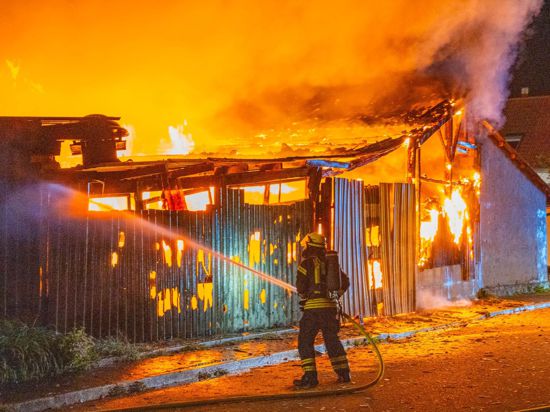 Ein Feuerwehrmann löscht einen Brand in Kehl-Neumühl.