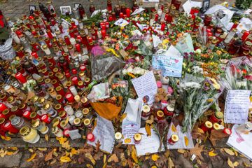 Briefe, Kerzen und Blumen liegen vor dem Eingang der Waldbachschule.