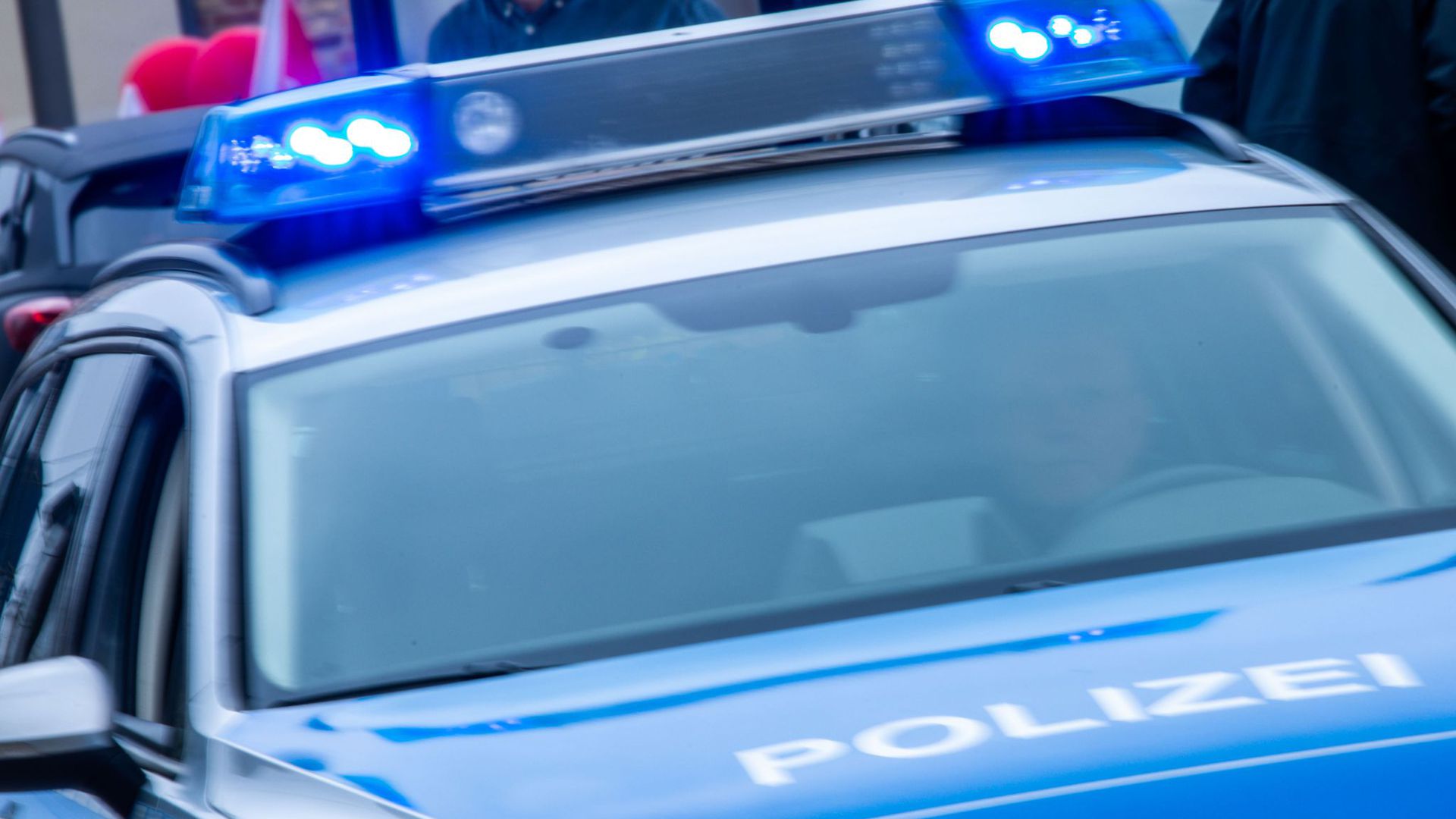 Ein Streifenwagen der Polizei ist mit Blaulicht im Einsatz.