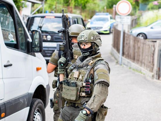 Polizisten des Sondereinsatzkommandos SEK stehen in einem Wohngebiet am Rand von Oppenau.  