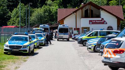 Polizeifahrzeuge stehen am 12. Juli auf einem Sammelplatz nahe Oppenau vor einem Sportlerheim. 