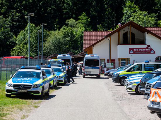 Polizeifahrzeuge stehen am 12. Juli auf einem Sammelplatz nahe Oppenau vor einem Sportlerheim. 