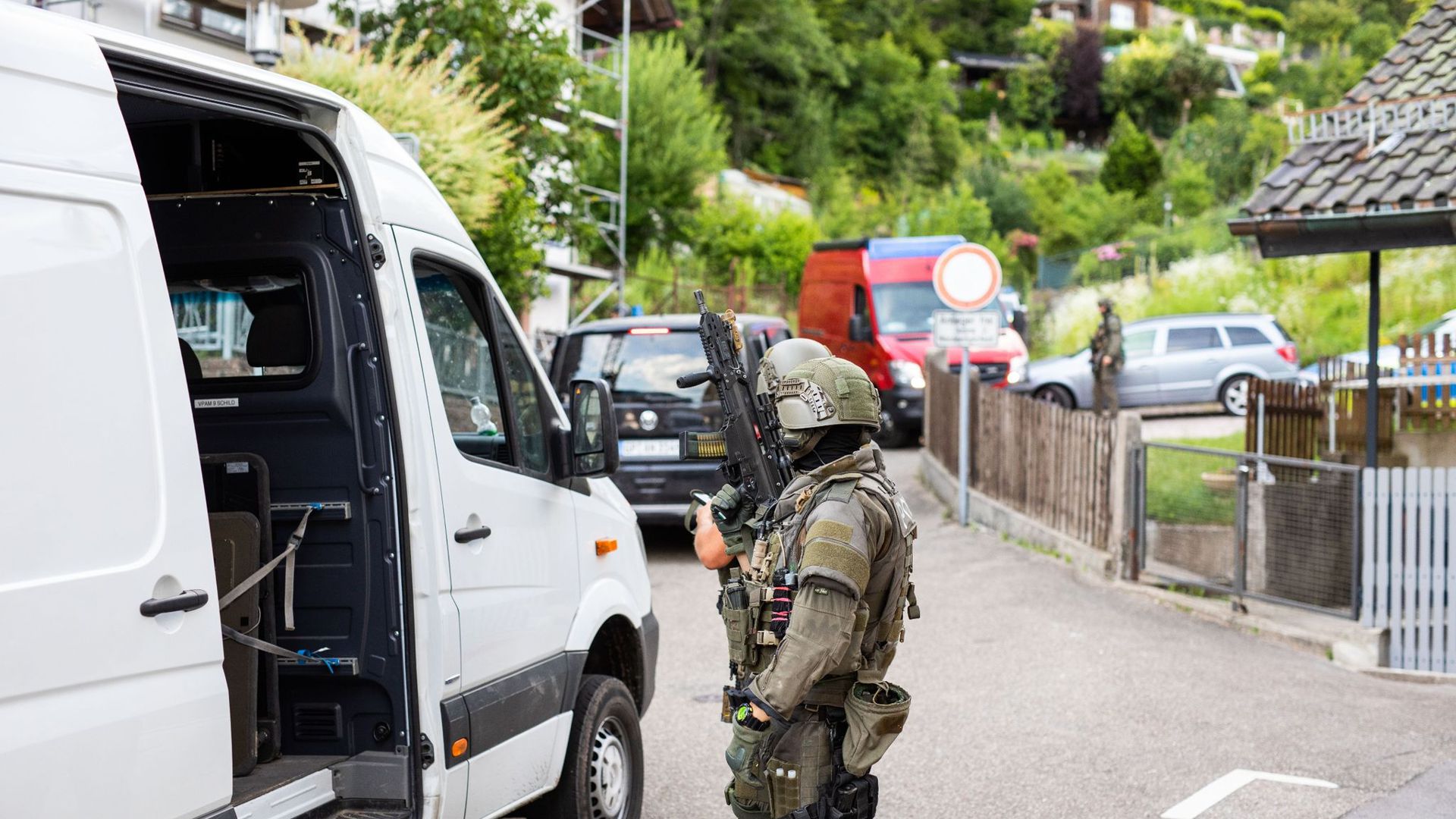 Polizisten des Sondereinsatzkommandos SEK stehen in einem Wohngebiet am Rand der Ortschaft Oppenau.