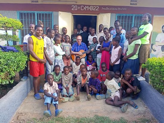 Willy Schneider, der Vorsitzende des Vereins „Afrikanische-Deutsche Partnerschaft Maleika e. V.“ beim Liedersingen im Kreis der Kinder im Waisenhaus „Children’s Home Malaika“