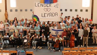 Schüler mit einem Transparent mit der Aufschrift „Lender Leyada“ und Musikinstrumenten.