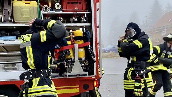Bei einer Großübung am Nationalparkzentrum Ruhestein legen sich Feuerwehrleute ihre Atemschutzgeräte an. 