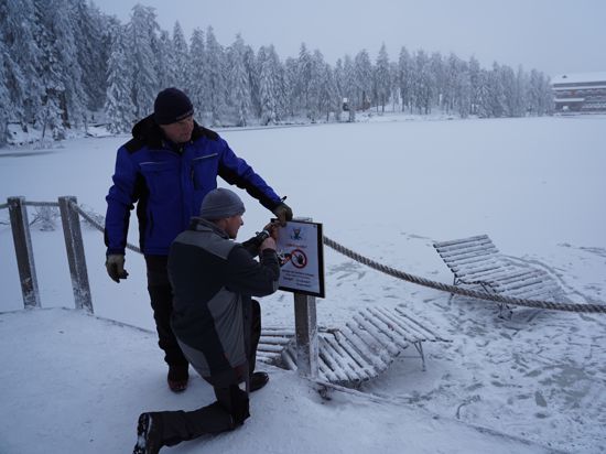 Betreten verboten: Johann Schnurr (links) und sein Sohn Michael Schnurr bringen Hinweisschilder an, nachdem Ausflügler sich auf die Eisfläche gewagt hatten.