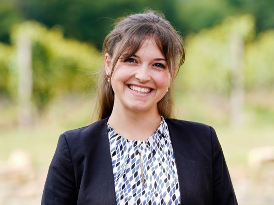 Sina Erdrich (Baden), Kandidatin bei der Wahl zur Deutschen Weinkönigin, steht vor einem Weinberg.