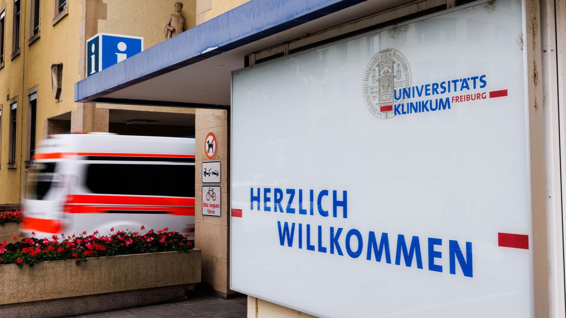Ein Krankenwagen fährt durch ein Portal auf das Gelände der Freiburger Universitätsklinik.