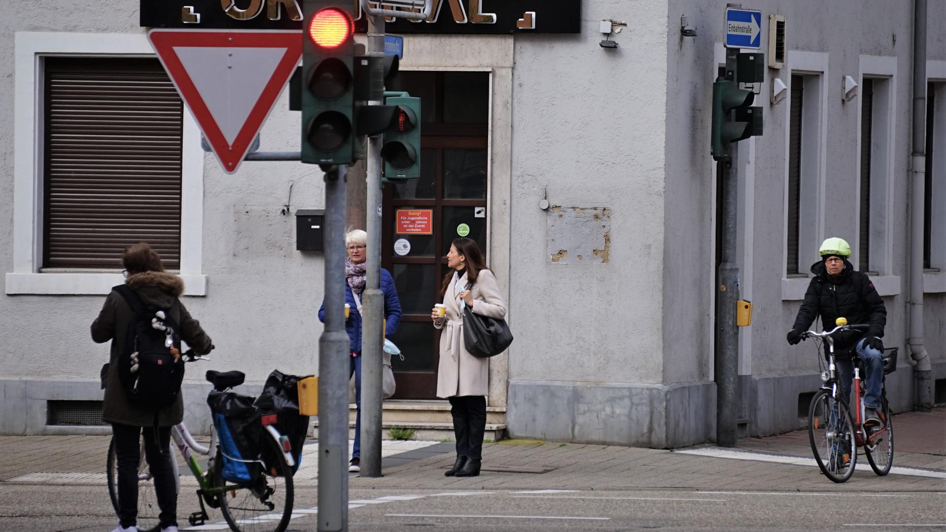 Fahrradfahrer und Fußgänger warten an einer Ampel in Rastatt. 