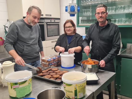 Einsatz mit Herz und Hand: Frank und Tanja Pasel (von links) bereiten zusammen mit Volker Graf das Essen für die Bedürftigen in der Küche des Gemeindehauses St. Alexander vor. 
