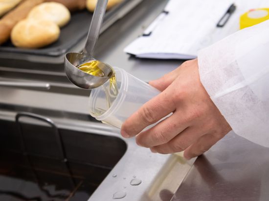 Ein Lebensmittelkontrolleur vom Landratsamt München nimmt eine Öl-Probe aus einer Fritteuse der SV-Betriebskantine. 