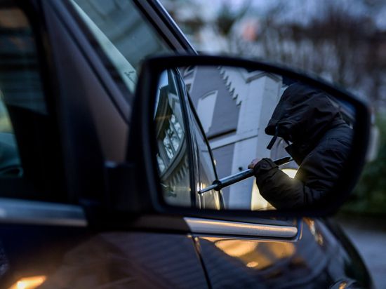ILLUSTRATION - Ein Mann versucht eine Autotür mit einer Metallstange aufzubrechen (gestellte Szene). (zu "Autodiebstähle in Sachsen-Anhalt") +++ dpa-Bildfunk +++