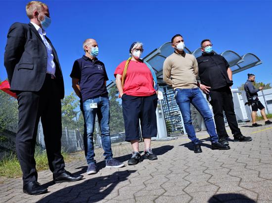 Vertreter von Betriebsrat und IG Metall stehen vor dem Daimler-Werk in Rastatt.