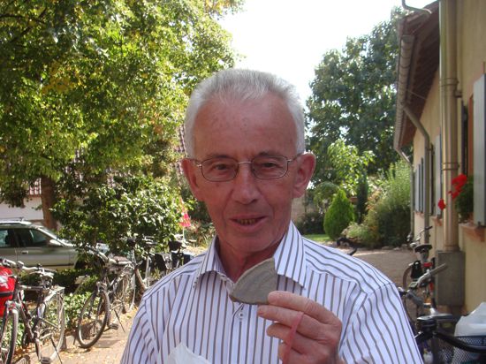 Franz Ruf, ein älterer Herr, hält eine Tonscherbe in die Kamera