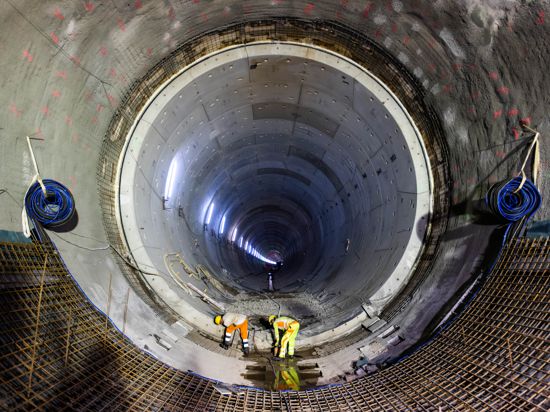 Zwei Handwerker arbeiten auf der Baustelle des Bahntunnels in Rastatt. 