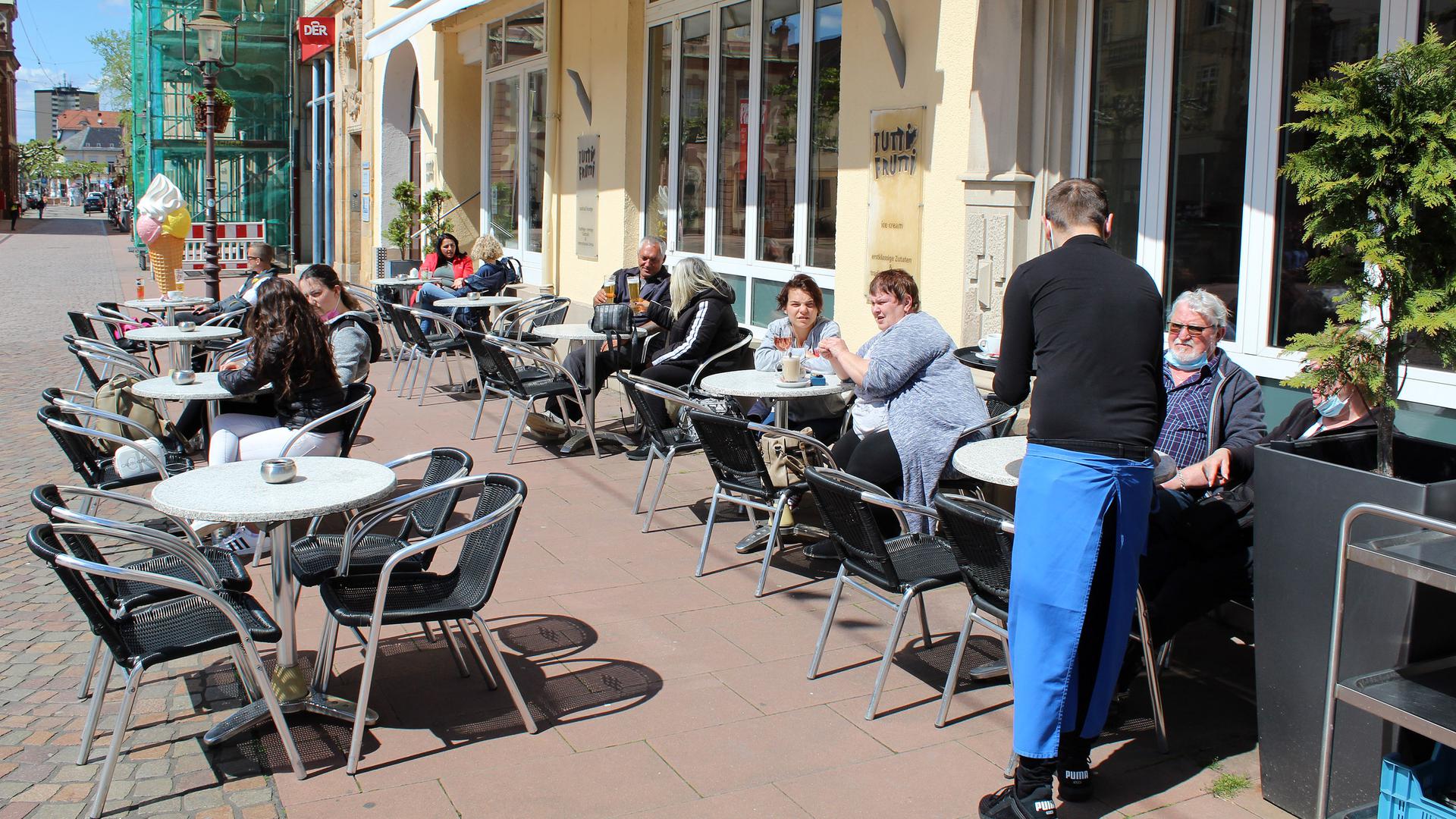 Vor dem Eiscafé Tutti Frutti in der Fußgängerzone in Rastatt sitzen nach Corona-Erleichterungen wieder erste Gäste.