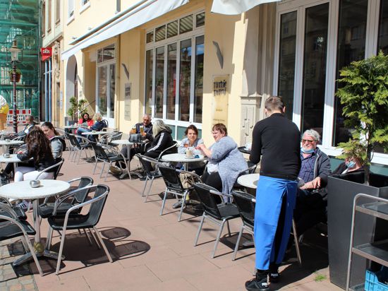 Vor dem Eiscafé Tutti Frutti in der Fußgängerzone in Rastatt sitzen nach Corona-Erleichterungen wieder erste Gäste.