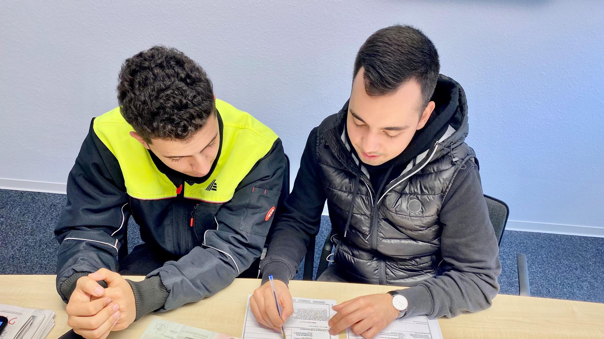 Schreibarbeit: Omar Jaafar (links) und Mustafa Özkan beugen sich über ein Antragsformular. Kurz vor knapp verlängerte die Rastatter Ausländerbehörde Jaafars Fiktionsbescheinigung. 