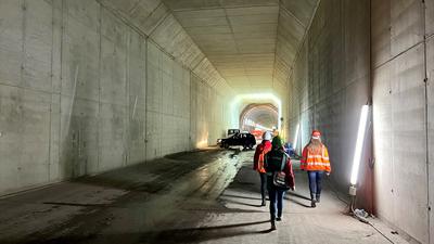 Journalisten laufen in der neu gebohrten Weströhre des Bahntunnels Rastatt.