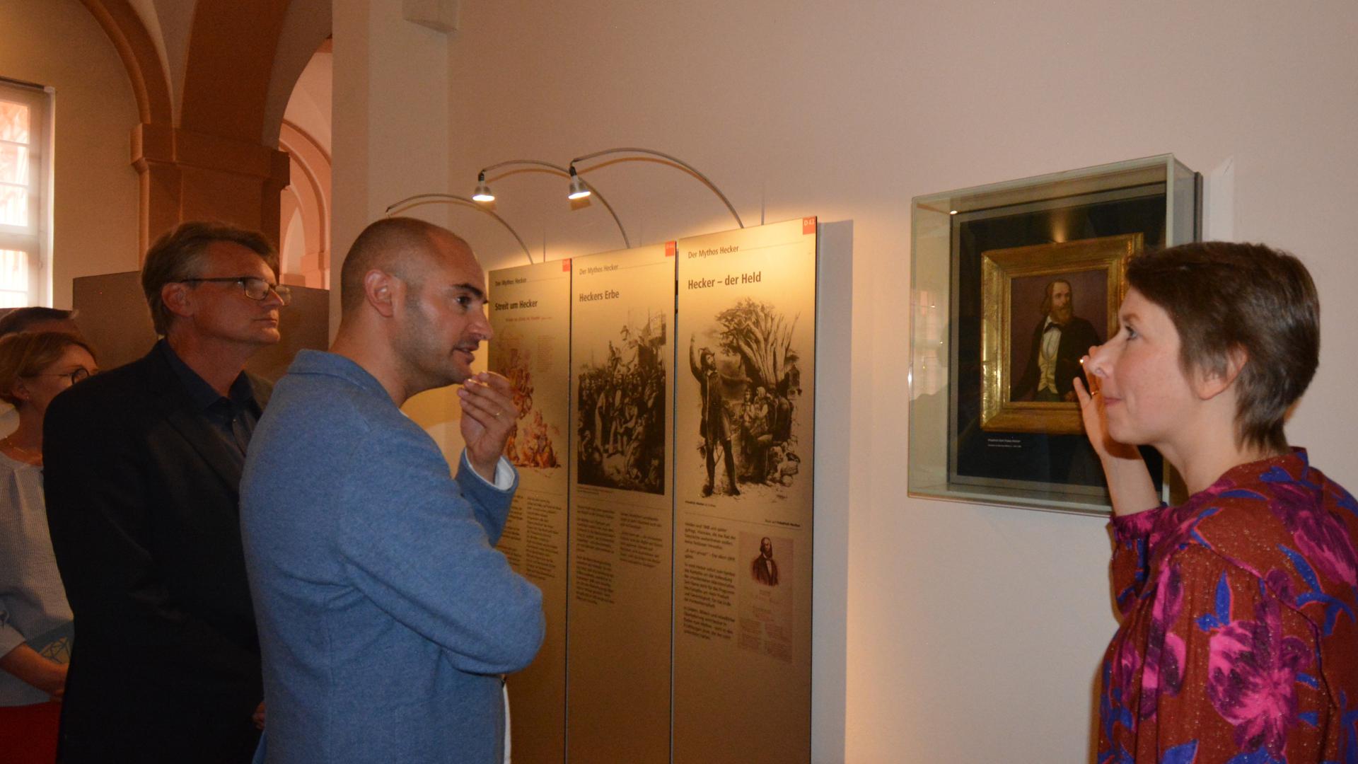 Daniel Bayaz und Elisabeth Thalhofer stehen vor den Bildern Friedrich Heckers.