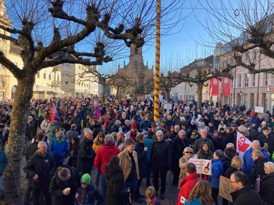 eine Menschenmenge mit Plakaten und Fahnen steht auf dem Rastatter Marktplatz, im Hintergrund die Stadtkirche Sankt Alexander