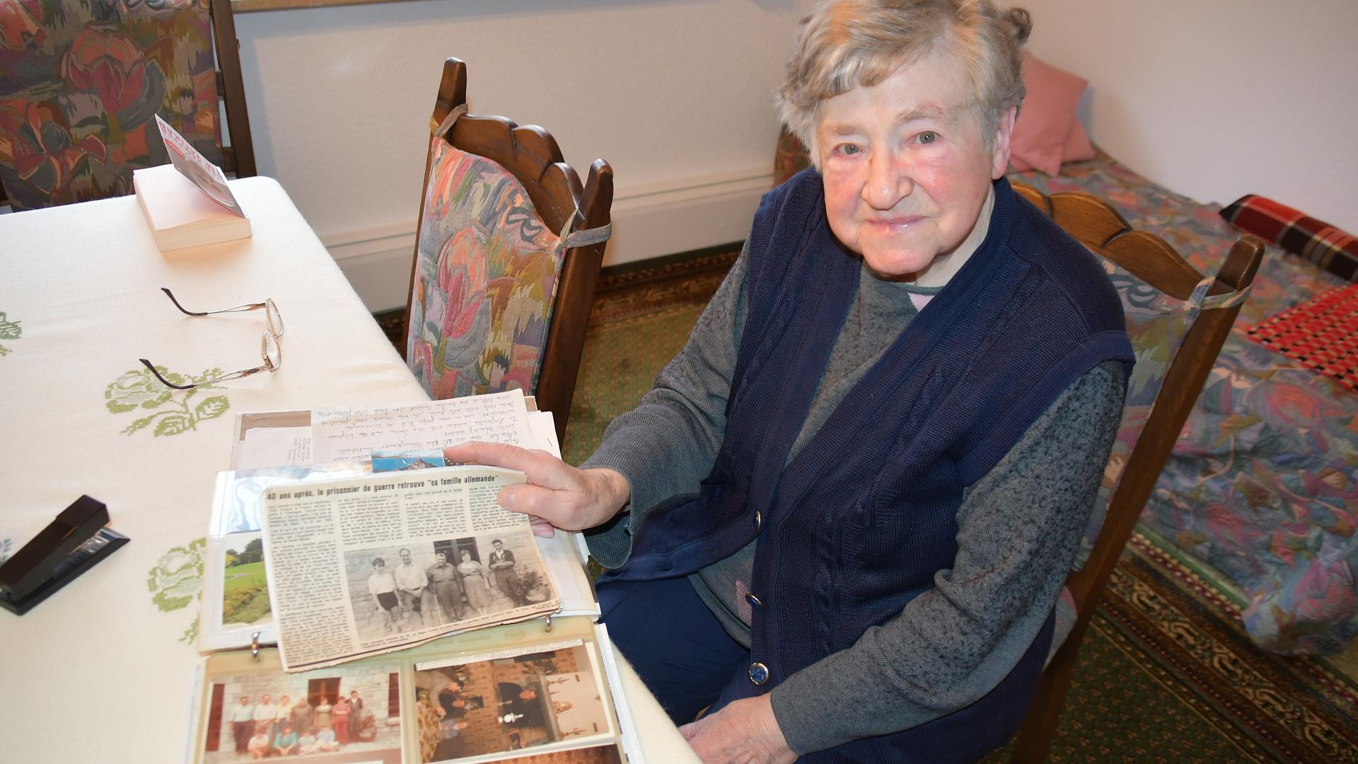 Tiefe Verbundenheit: Die 88-jährige Anne Frank hält den französischen Zeitungsartikel in der Hand, in dem die Freundschaft zwischen ihrem Ehemann Walter und dem ehemaligen Kriegsgefangenen Leon Leconte beschrieben wird. 