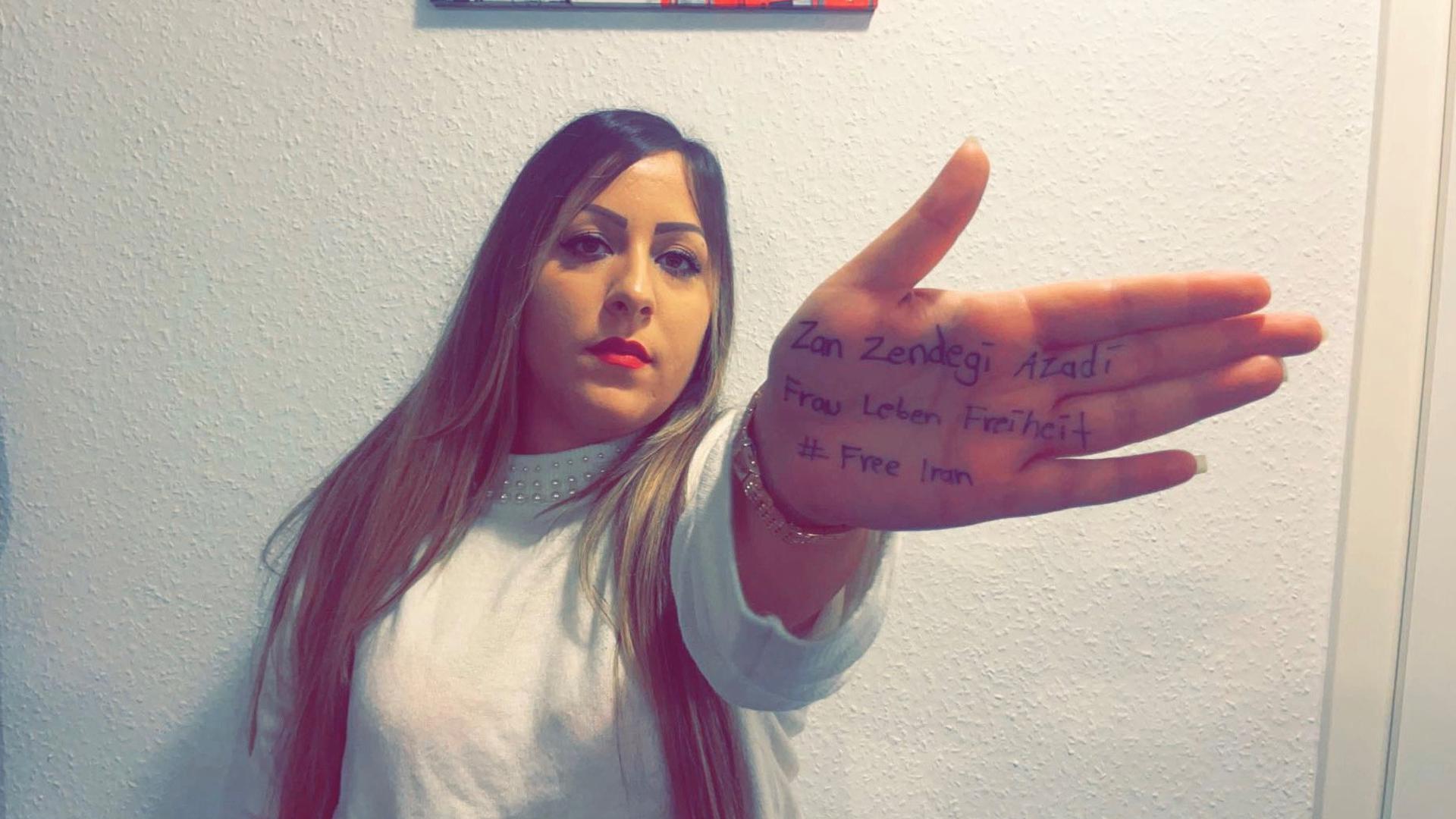 Frau, Leben, Freiheit: Auf ihre Handflächen hat Mona Langroodi die Schlagworte der Protestbewegung geschrieben, die seit Mahsa Aminis Tod von Protestierenden im Iran sowie international genutzt wird.