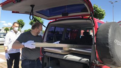 Ein Mann belädt einen Transporter mit Holzbalken