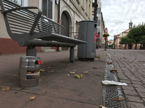 Müll an einer Sitzbank auf dem Rastatter Marktplatz, im Hintergrund das historische Rathaus