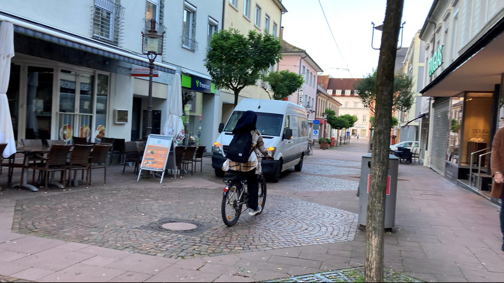 Radfahren verboten: Eine Frau fährt mit ihrem Fahrrad durch die Poststraße. Die Menschen in Rastatt haben unterschiedliche Meinungen über das unerlaubte Fahrradfahren in der Fußgängerzonen.