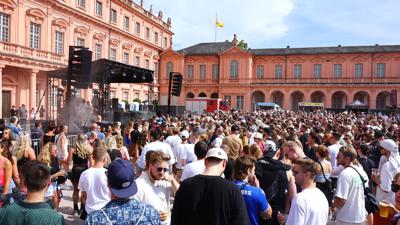 Tausende Menschen tanzen im Rastatter Schlosshof zur Musik von DJ Fritz Kalkbrenner beim Festival Red Residence.