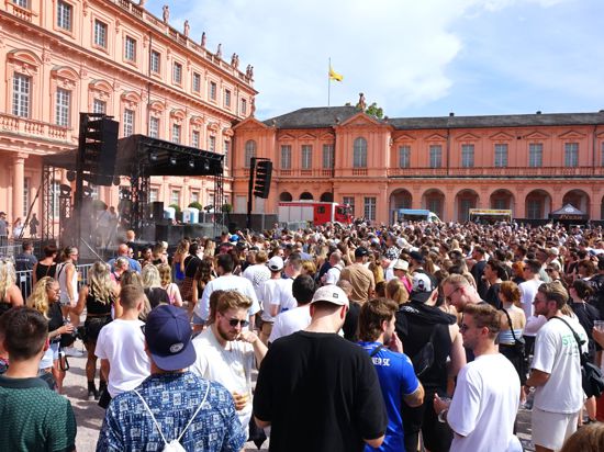 Tausende Menschen tanzen im Rastatter Schlosshof zur Musik von DJ Fritz Kalkbrenner beim Festival Red Residence.