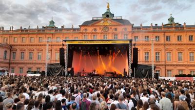 Publikum im Rastatter Schlosshof beim Open-Air-Konzert von Tom Odell und Band im Rahmen der Schlossfestspiele im Juli 2023.