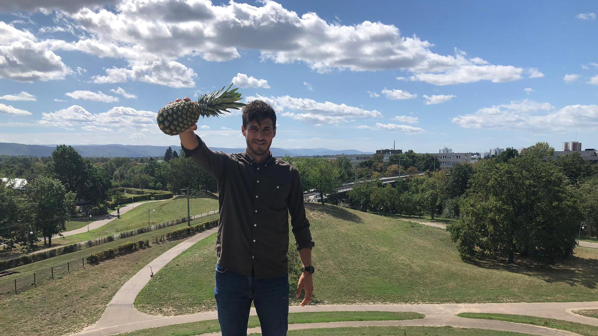 Ein Mann auf dem Hügel mit Ananas in der Hand 