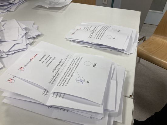 Stimmzettel für den Bürgerentscheid in Bischweier zum Mercedes-Logistikzentrum liegen auf einem Tisch.