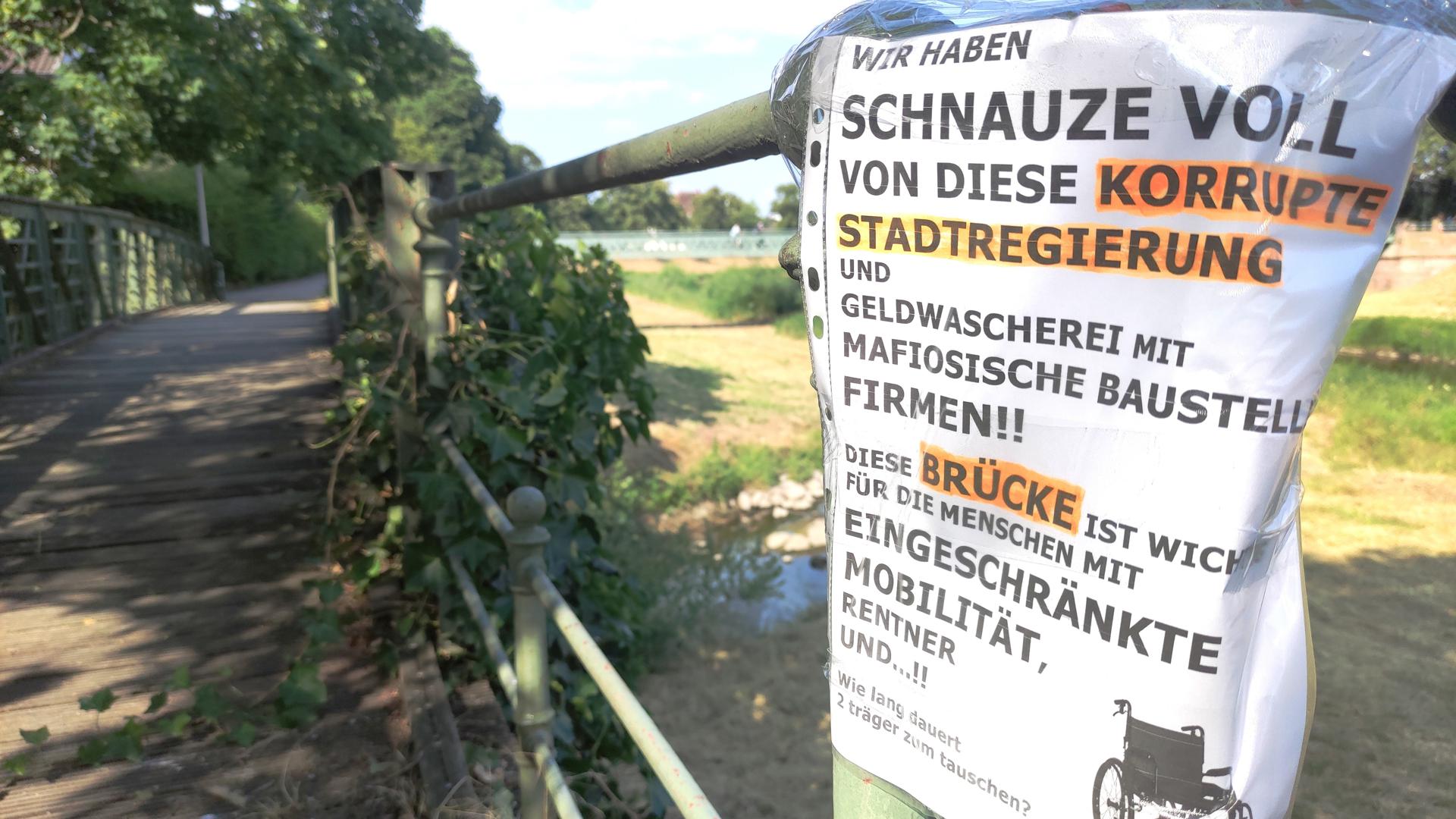 Ein Anschlag am Geländer des gesperrten Schachtelbachstegs in Rastatt bezichtigt die Stadtverwaltung mafiöser Praktiken.