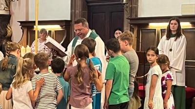 Pfarrer Ralf Dickerhof mit Kindern in der Stadtkirche St. Alexander.