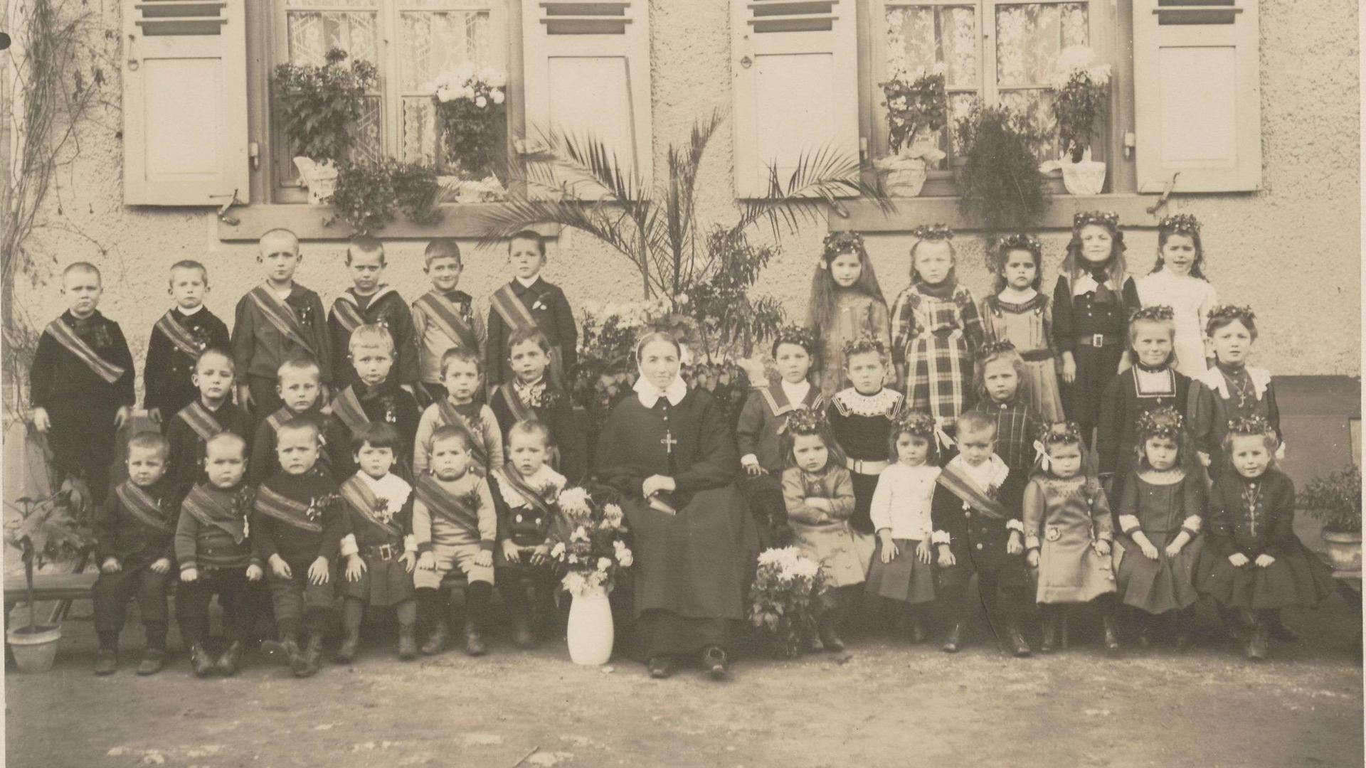 Zöglinge der evangelischen Kleinkinderschule Durmersheim, die von einer Diakonisse betreut werden, im Jahr 1912. 