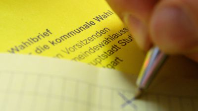 Ein Mann kreuzt einen Wahlzettel der Briefwahl für die Kommunalwahl in Baden-Württemberg an.
