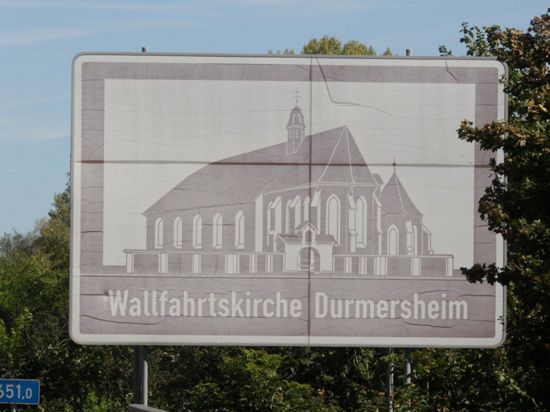 Braune Hinweistafel mit Aufschrift „Wallfahrtskirche Bickesheim“ an der A5.                         