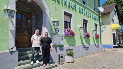 Ein Mann und seine Tochter stehen vor dem Gasthaus „Grüner Baum“ in Hügelsheim.  
