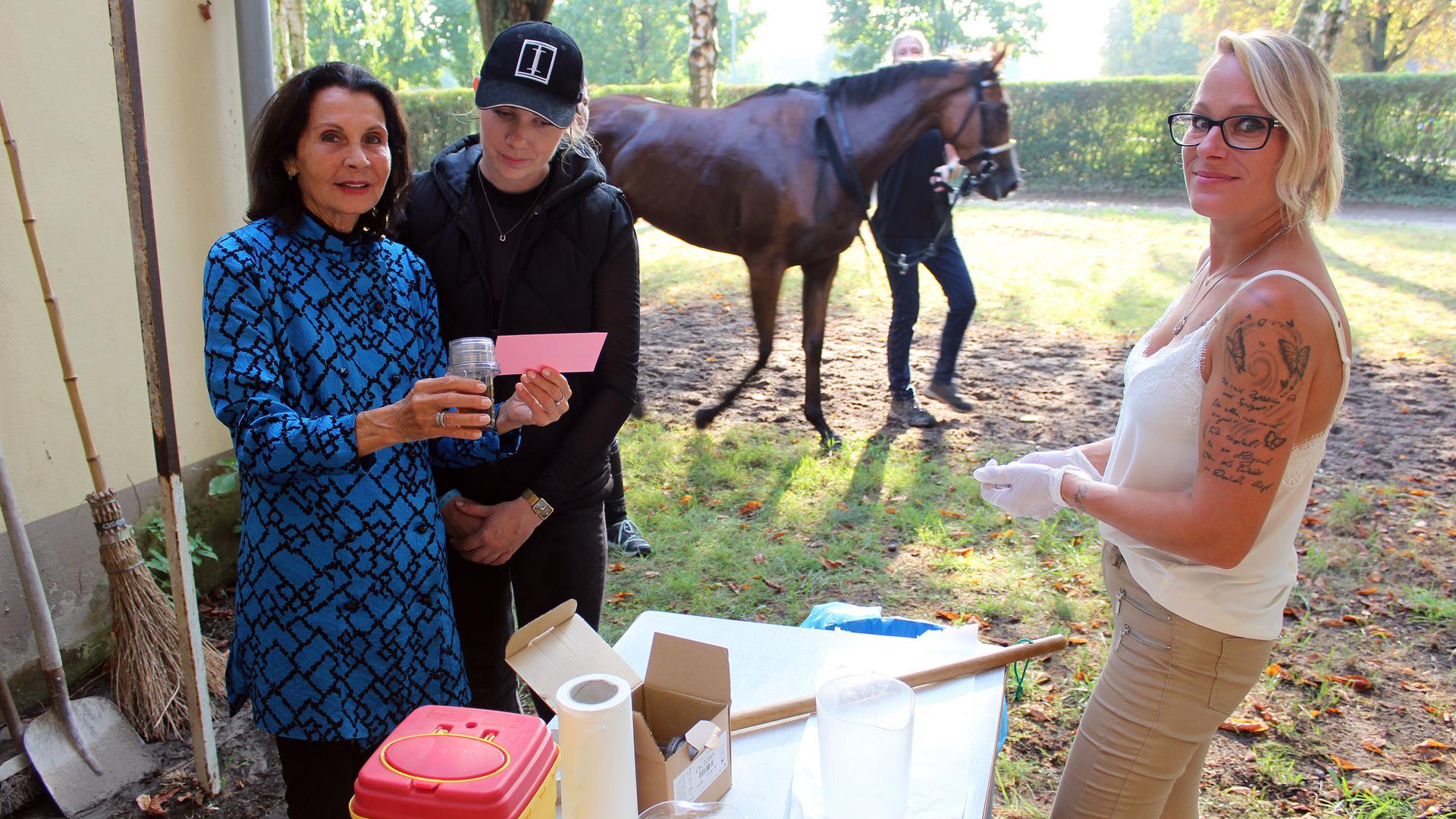 Als Dopingkontrolleure im Dauereinsatz: Karin Ortlieb (links) versiegelt im Beisein einer Pferdeführerin (Mitte) die Urinproben, die Entnehmerin Astrid Palau (rechs) dem zu überprüfenden Pferd entnommen hat.