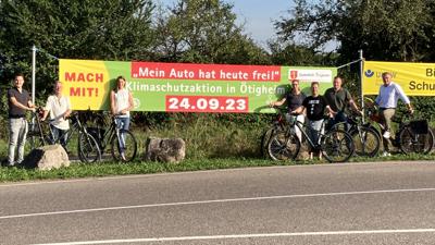 Leute mit Fahrrad vor dem Banner zum autofreien Sonntag in Ötigheim.